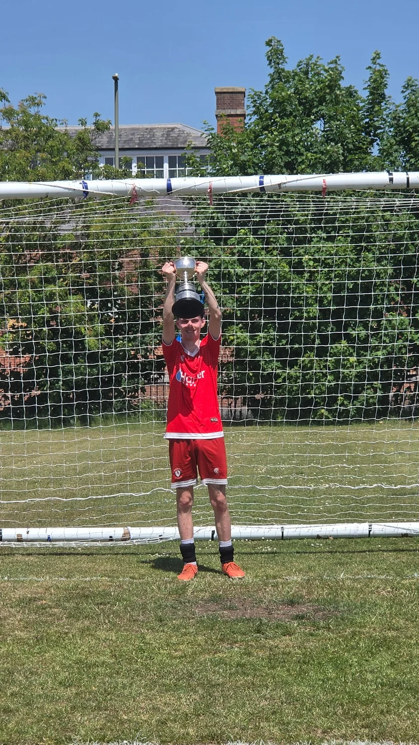 Heron United player lifting the trophy