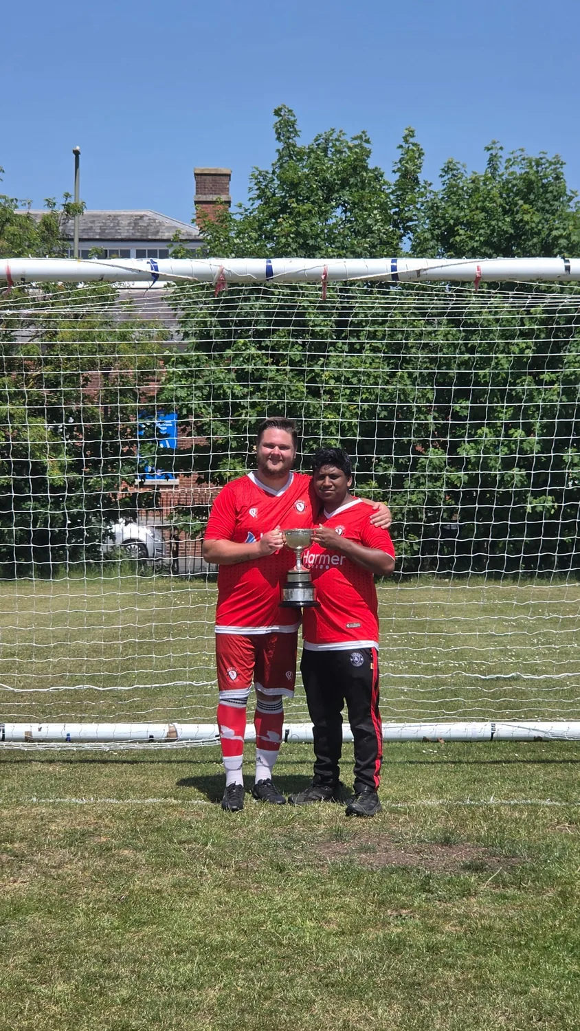 Heron United players holding the trophy