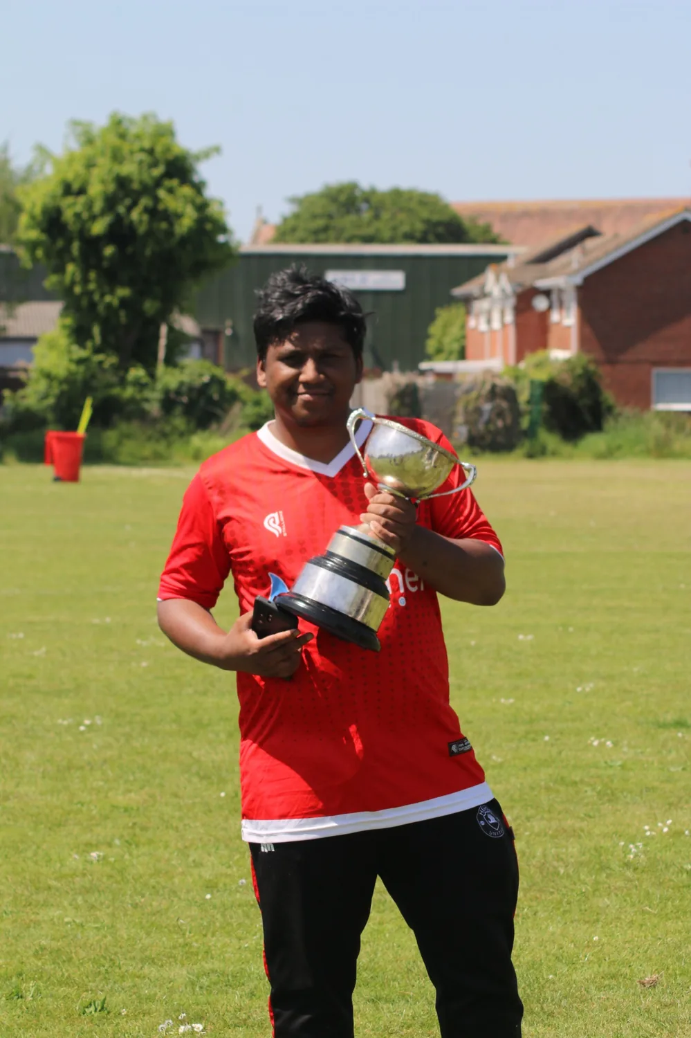 Heron United player holding the trophy